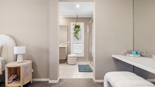 a white bathroom with a toilet and a sink at Secret Haven in Safety Beach