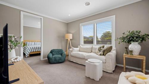 a living room with a white couch and a window at Secret Haven in Safety Beach