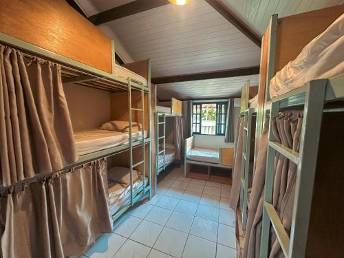 a room with several bunk beds in a house at Clan.Destino Hostel in Ilhabela