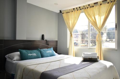 a bedroom with two beds and a window at Ayenda Balcon Real in Tunja