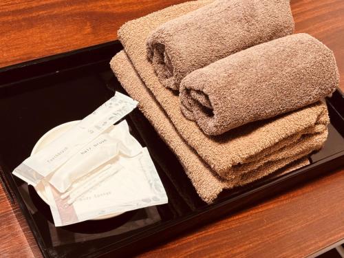 a suitcase with towels and a pile of receipts at ゲストハウス元町 in Ise