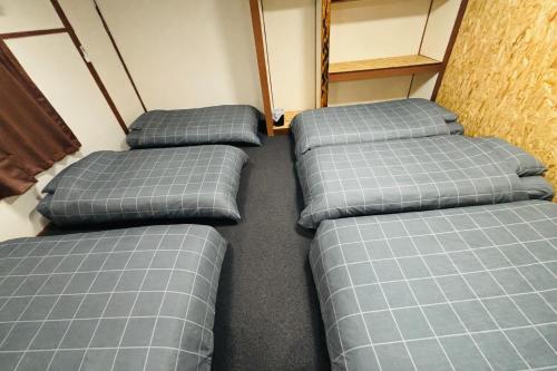 four pillows are lined up in a room at ゲストハウス元町 in Ise