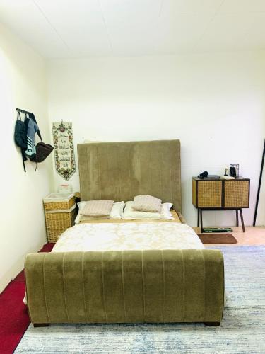 a bedroom with a large bed with a large headboard at Rooms & Suites Western Dhafra Housing in Ghayathi