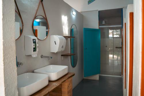a bathroom with a sink and a mirror at Clan.Destino Hostel in Ilhabela