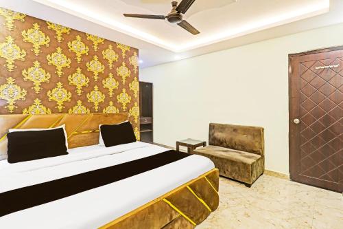 a bedroom with a bed and a chair at Super Hotel O Kathauta Jheel Malhaur Gomti Nagar in Lucknow