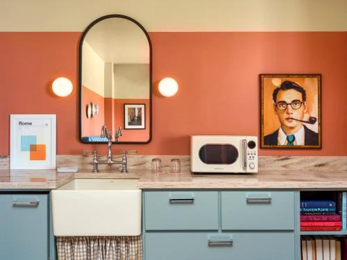 a bathroom with a sink and a mirror and a microwave at Hotel Trouvail Miami Beach in Miami Beach