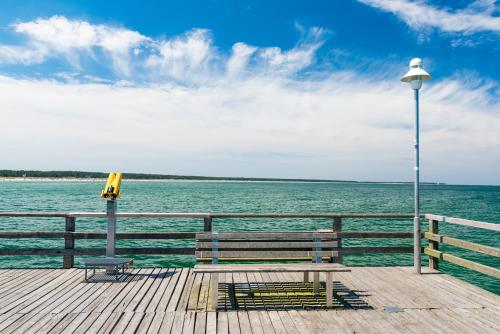 a wooden pier with a bench and a street light at Ferienhotel Alter Bahnhof garni in Prerow