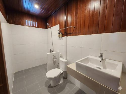 a bathroom with a white toilet and a sink at Coriana Dive Resort in Waisai