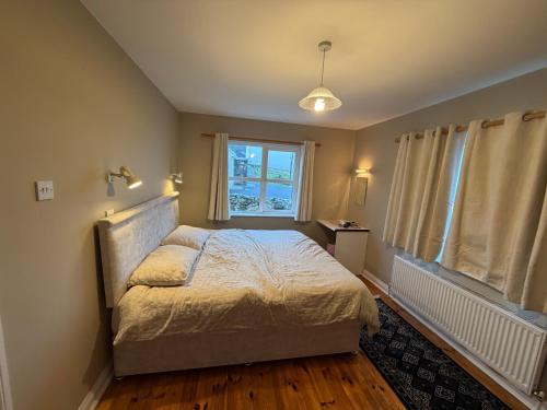 a bedroom with a bed and a window at Trá Leathan in Doolin