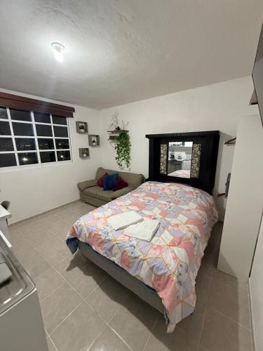 a bedroom with a bed and a couch at Private Loft Free Parking Pet friendly in Chapulco
