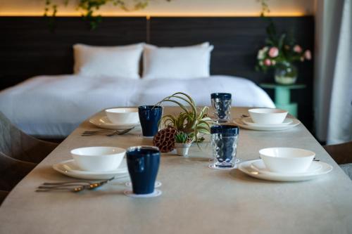 a table with plates and bowls and cups on a bed at Doutonbori Crystal Exe in Osaka