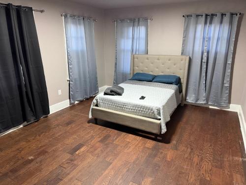 a bedroom with a bed with black curtains and wooden floors at Casa Tabacon CR USA in Trenton