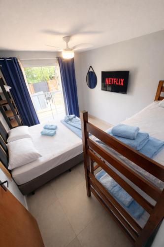 a bedroom with two beds and a sign on the wall at Casa do Sol - 300M da Praia - Ar condicionado in São Pedro da Aldeia