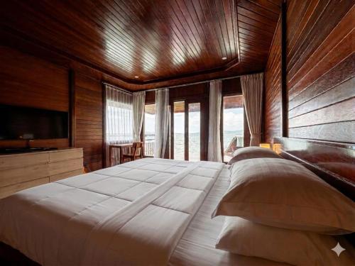 a large bedroom with a large bed and a television at Coriana Dive Resort in Waisai