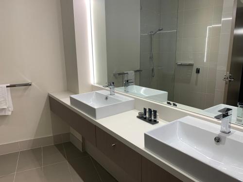 a bathroom with two sinks and a large mirror at Alexandra Hills Hotel in Cleveland