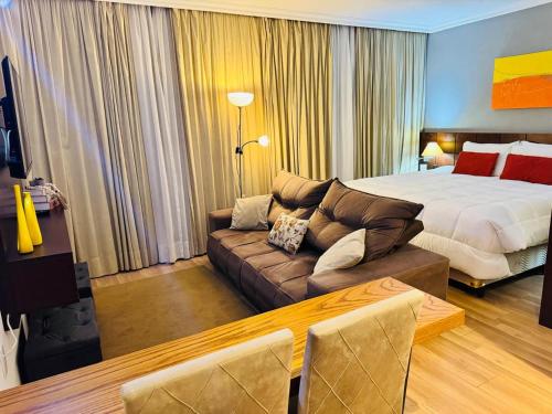 a hotel room with a bed and a couch at Blu Flat Prime Verbo Divino in São Paulo