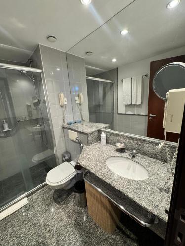 a bathroom with a toilet and a sink and a shower at Blu Flat Prime Verbo Divino in São Paulo