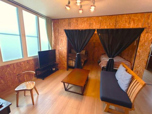 a room with a bedroom with a bed and a tv at Rustic Modern House in Hakodate in Hakodate