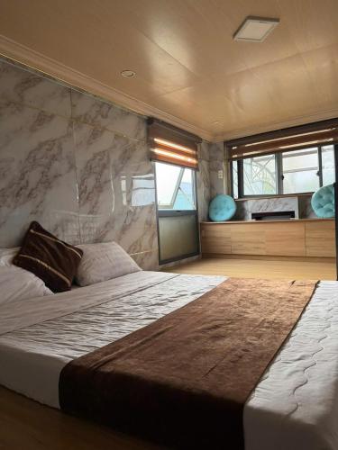 a bedroom with a large bed with a stone wall at Centralhome 2 in Plei Brêng