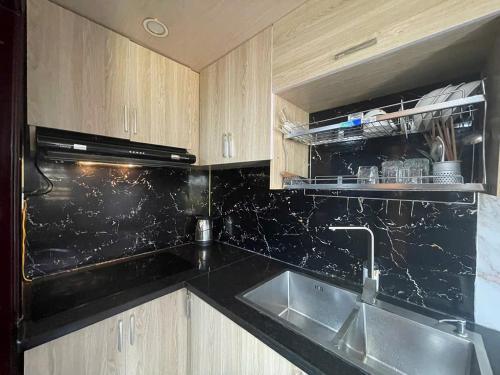 a kitchen with a sink and a black counter top at Centralhome 2 in Plei Brêng