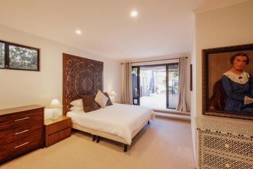 a bedroom with a bed and a painting on the wall at Mokum House Designer Escape with Pool Sauna in Brisbane