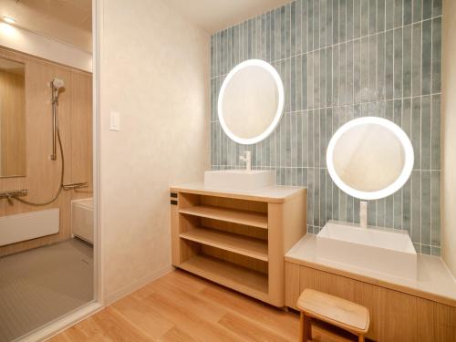 a bathroom with a sink and two mirrors at Tateshina Lake Resort in Tateshina