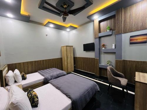 a hotel room with two beds and a chair at Karachi Inn in Karachi