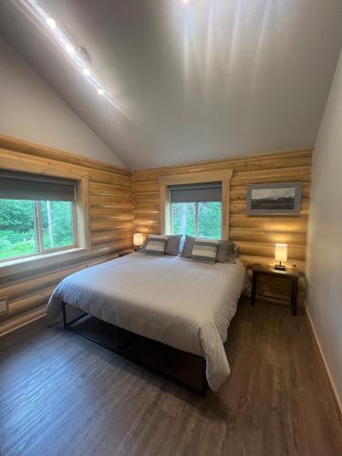 a bedroom with a large bed in a room with wooden walls at Clear Creek Cabins in Seward