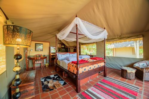 a bedroom with a canopy bed in a tent at Buffalo's Rest Greenpark-Naivasha in Naivasha