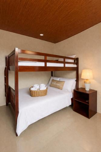 a bedroom with a bunk bed with white sheets at Estellie Resthouse in Maya