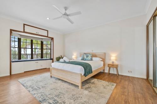 a white bedroom with a bed and a window at Beachfront - Opposite Boat Ramp in Golden Beach