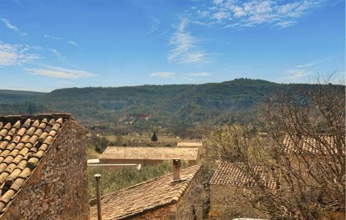 a group of buildings with mountains in the background at Maison En Pierres in Rustrel