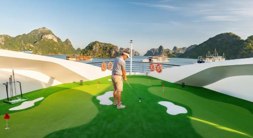 a man is playing golf on a virtual golf course at Diana Cruises Halong Bay - Luxury by Venus Group in Ha Long