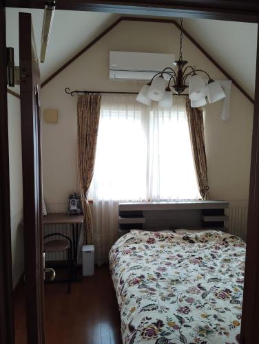 a bedroom with a bed and a window at シンデレラ城風 邸宅のゲストハウス民泊 in Tosa