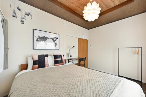 a bedroom with a large bed and a wooden ceiling at INUYAMA BASE Vacation rental in Inuyama