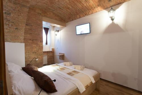 1 dormitorio con 1 cama y TV en la pared en Guesthouse BED 4 YOU en Zagreb