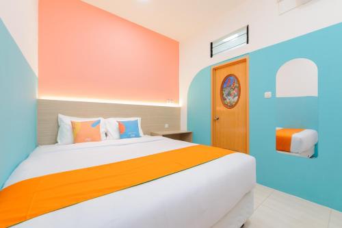 a bedroom with a bed with orange and blue walls at Sans Hotel Cengkareng in Jakarta