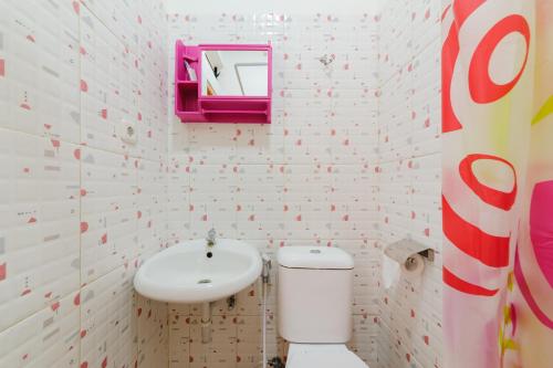 a bathroom with a toilet and a sink at Sans Hotel Cengkareng in Jakarta