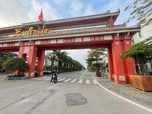 a person riding a motorcycle under a red bridge at Fullhouse Riverside Homestay in Hue