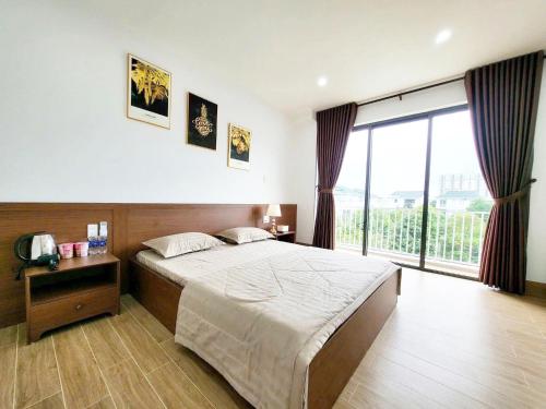a bedroom with a bed and a large window at Fullhouse Riverside Homestay in Hue