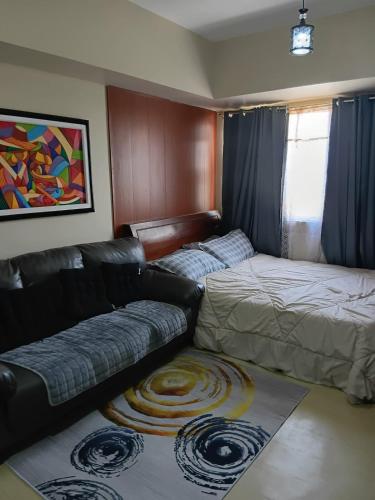 a living room with a couch and a bed at Josephine's place at Avida Aspira Tower 2 CDO in Cagayan de Oro