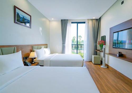 a hotel room with two beds and a television at Intechco Hotel S1-25 sầm Sơn in Sầm Sơn