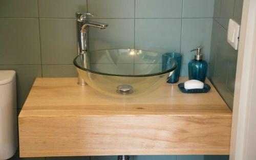 a glass bowl sink on a wooden counter in a bathroom at Frasteva Resort in Valverde