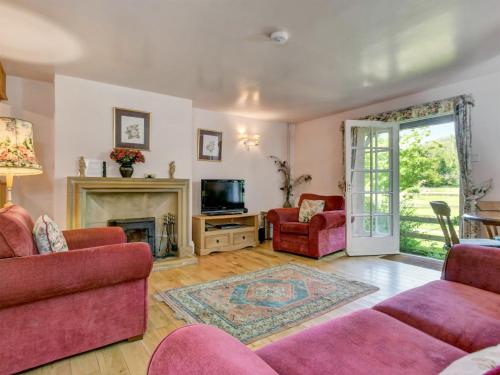 a living room with pink furniture and a fireplace at Annexe- Ukc4917 in Timberscombe