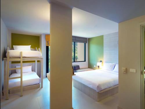 a bedroom with two beds and a large window at ibis Styles Krabi Ao Nang in Ao Nang Beach