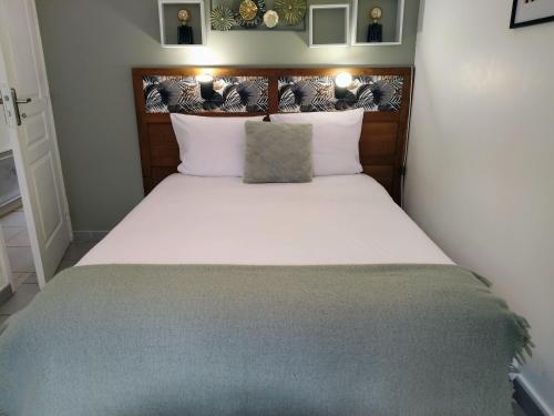a bedroom with a large bed with white sheets at Maison avec jardin, calme et ensoleillée à 2 minutes du centre-ville in Cabourg