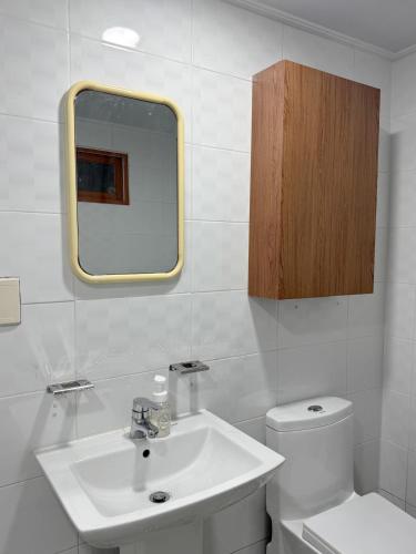a bathroom with a sink and a toilet and a mirror at juns house in Ulsan