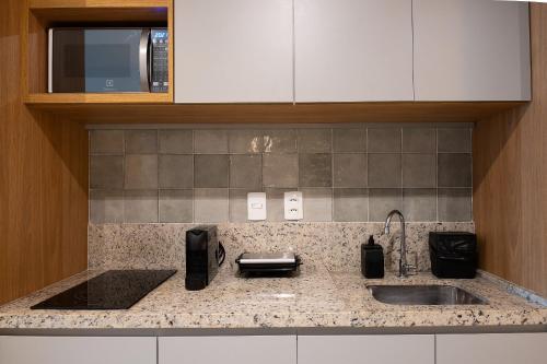 a kitchen counter with a sink and a microwave at Skylux by Tegra in Rio de Janeiro