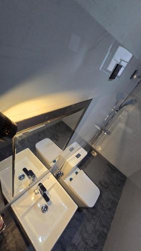 a bathroom with three sinks and a mirror at Villa Cascade in Akuressa
