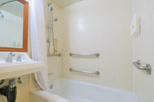 a bathroom with a shower and a sink at Ramada Plaza by Wyndham Waikiki in Honolulu